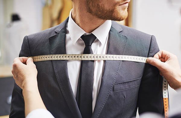 Tailor measuring a suit jacket